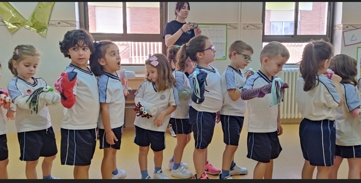 niños y niñas con calcetin marioneta en la mano