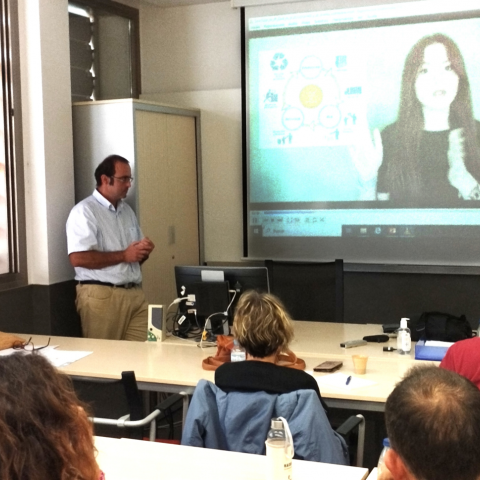 imagen aula con alumnos y profesor mirando pantalla