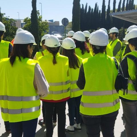 conjunto de personas equipadas con su EPI asistiendo a las explicaciones de otra en el exterior