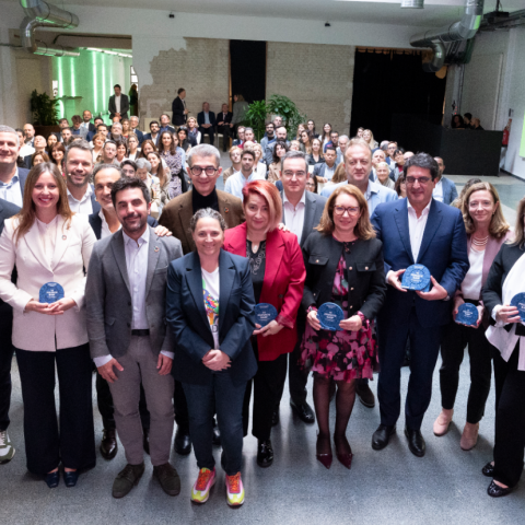 Todos los premiados con el cmisionado mirando a la cámara y mostrando sus galardones