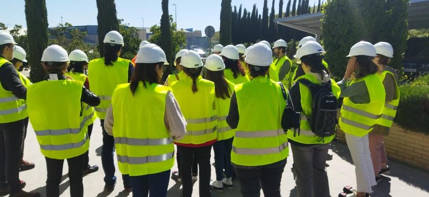 conjunto de personas equipadas con su EPI asistiendo a las explicaciones de otra en el exterior